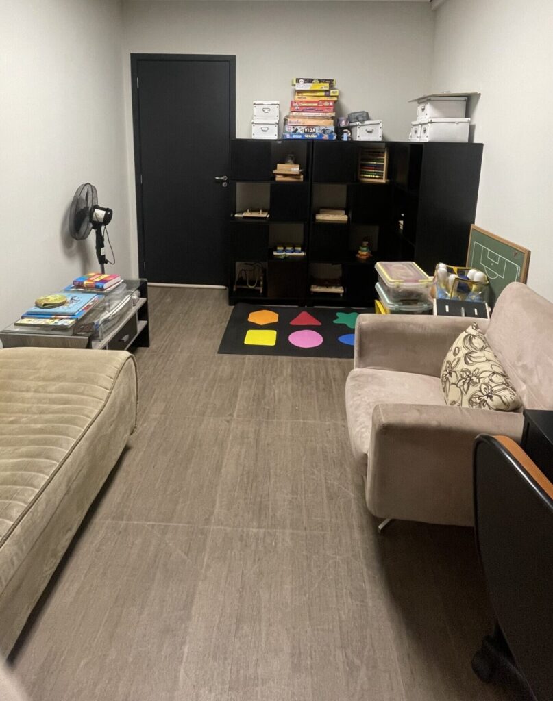 sala lúdica com poltrona, sofá, armário de brinquedos lúdicos